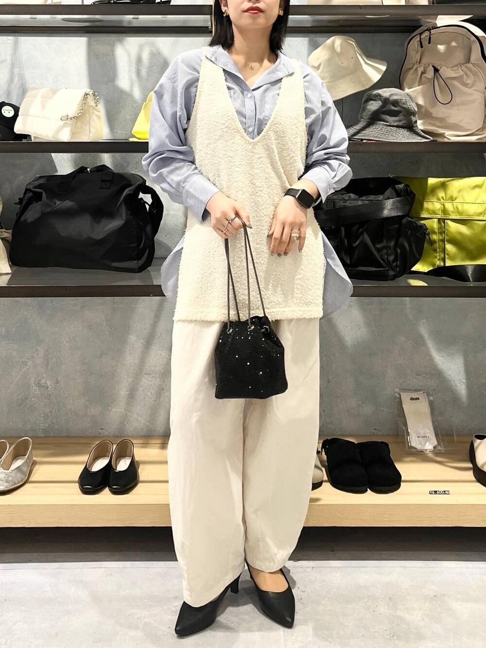 ブラック系のショルダーバッグ、ブラック系のパンプス、ブルー系のシャツ/ブラウスを着用したレディースの春コーディネートの3枚目の写真