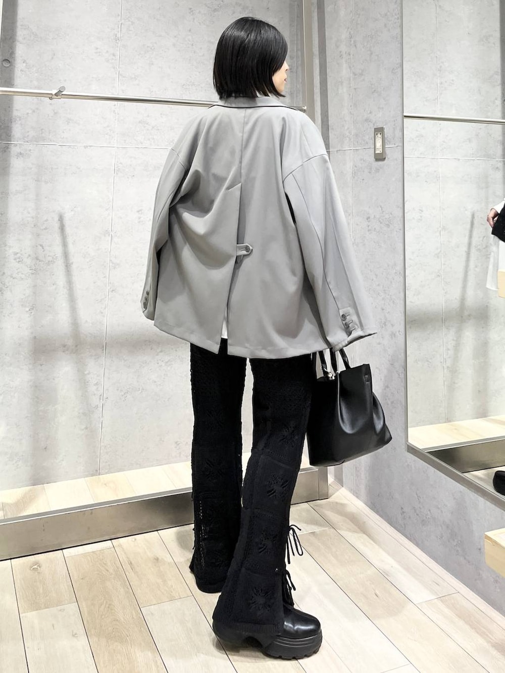 ブラック系のブーツ、ホワイト系のシャツ/ブラウス、グレー系のテーラードジャケットを着用したレディースの冬コーディネートの3枚目の写真