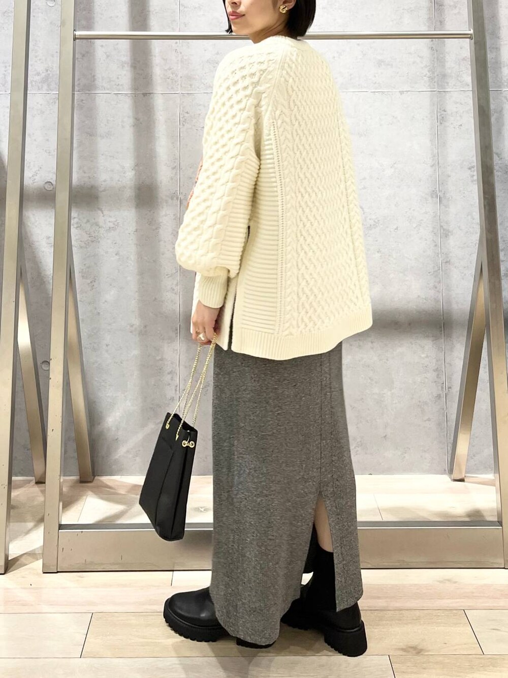 ブラック系のショルダーバッグ、ブラック系のブーツ、ホワイト系のその他トップスを着用したレディースの秋コーディネートの3枚目の写真