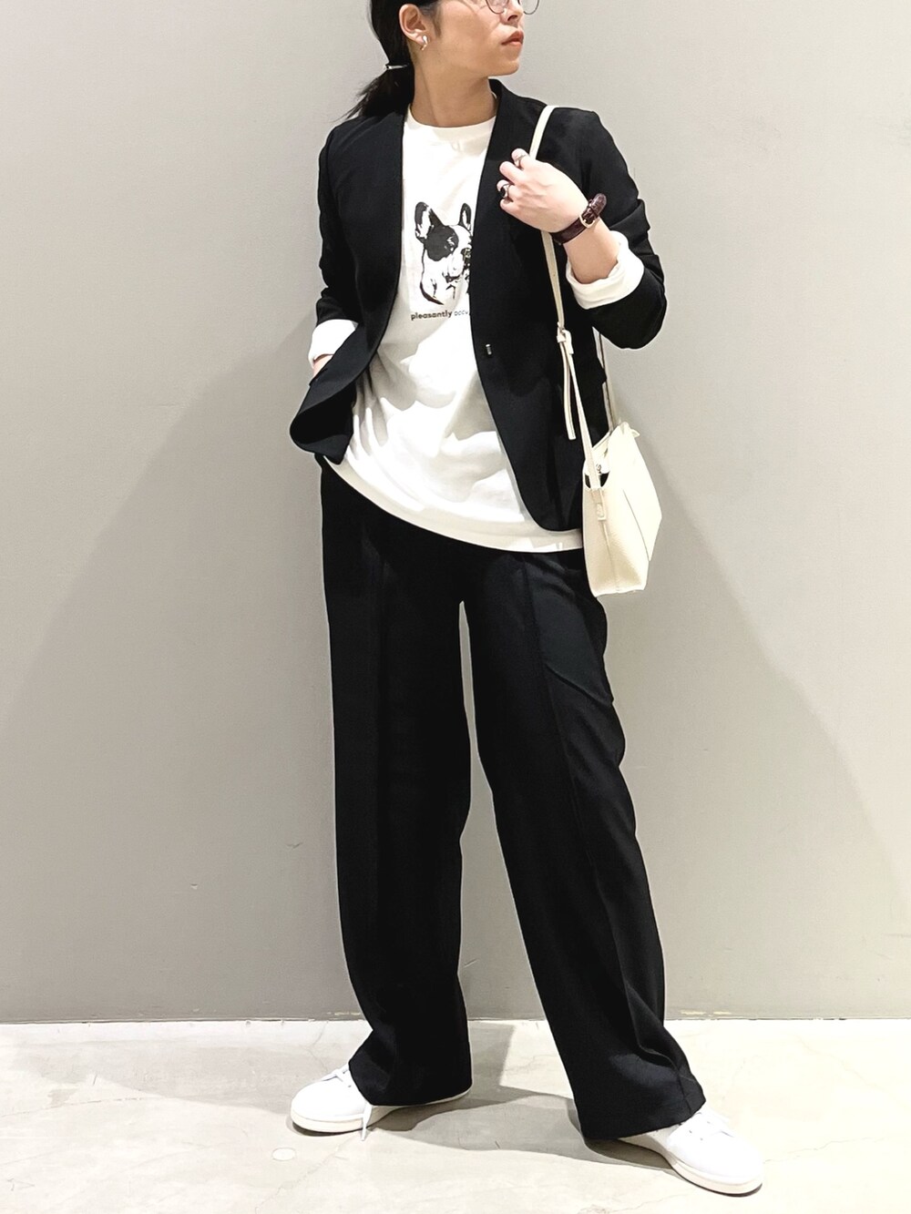 ブラック系のパンツ、ホワイト系のスニーカー、ホワイト系のショルダーバッグを着用したレディースの秋コーディネートの2枚目の写真