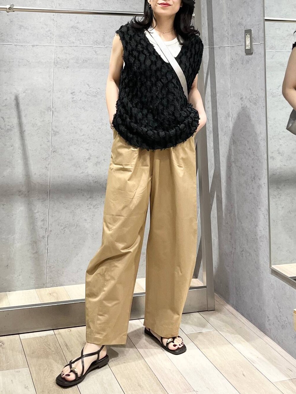 グレー系のショルダーバッグ、ホワイト系のTシャツ/カットソー、ベージュ系のその他パンツを着用したレディースの春コーディネートの2枚目の写真