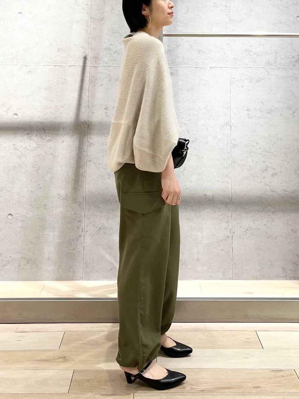 ホワイト系のキャミソール、ベージュ系のカーディガン/ボレロ、グリーン系のカーゴパンツを着用したレディースの秋コーディネートの4枚目の写真