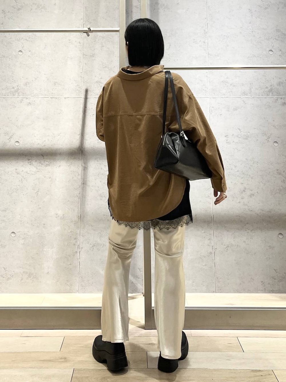 ブラック系のボストンバッグ、ブラック系のブーツ、イエロー系のシャツ/ブラウスを着用したレディースの冬コーディネートの4枚目の写真