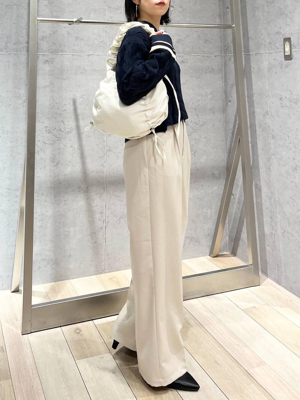 ブルー系のニット/セーター、ホワイト系のショルダーバッグ、ブラック系のパンプスを着用したレディースの冬コーディネートの8枚目の写真