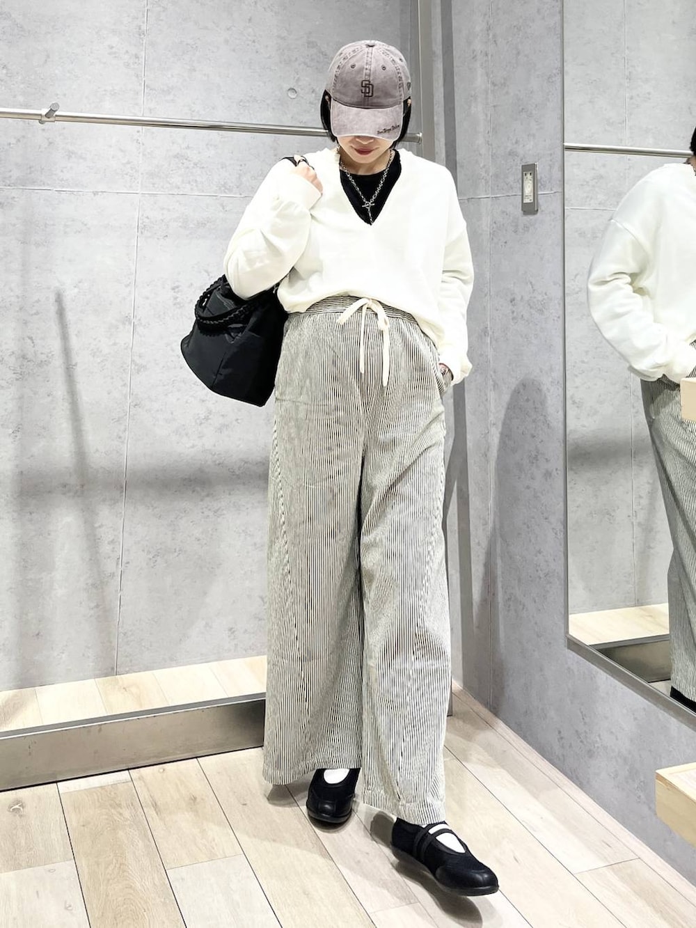 ブラック系のTシャツ/カットソー、ブラック系のショルダーバッグ、ブラック系のパンプスを着用したレディースの冬コーディネートの4枚目の写真