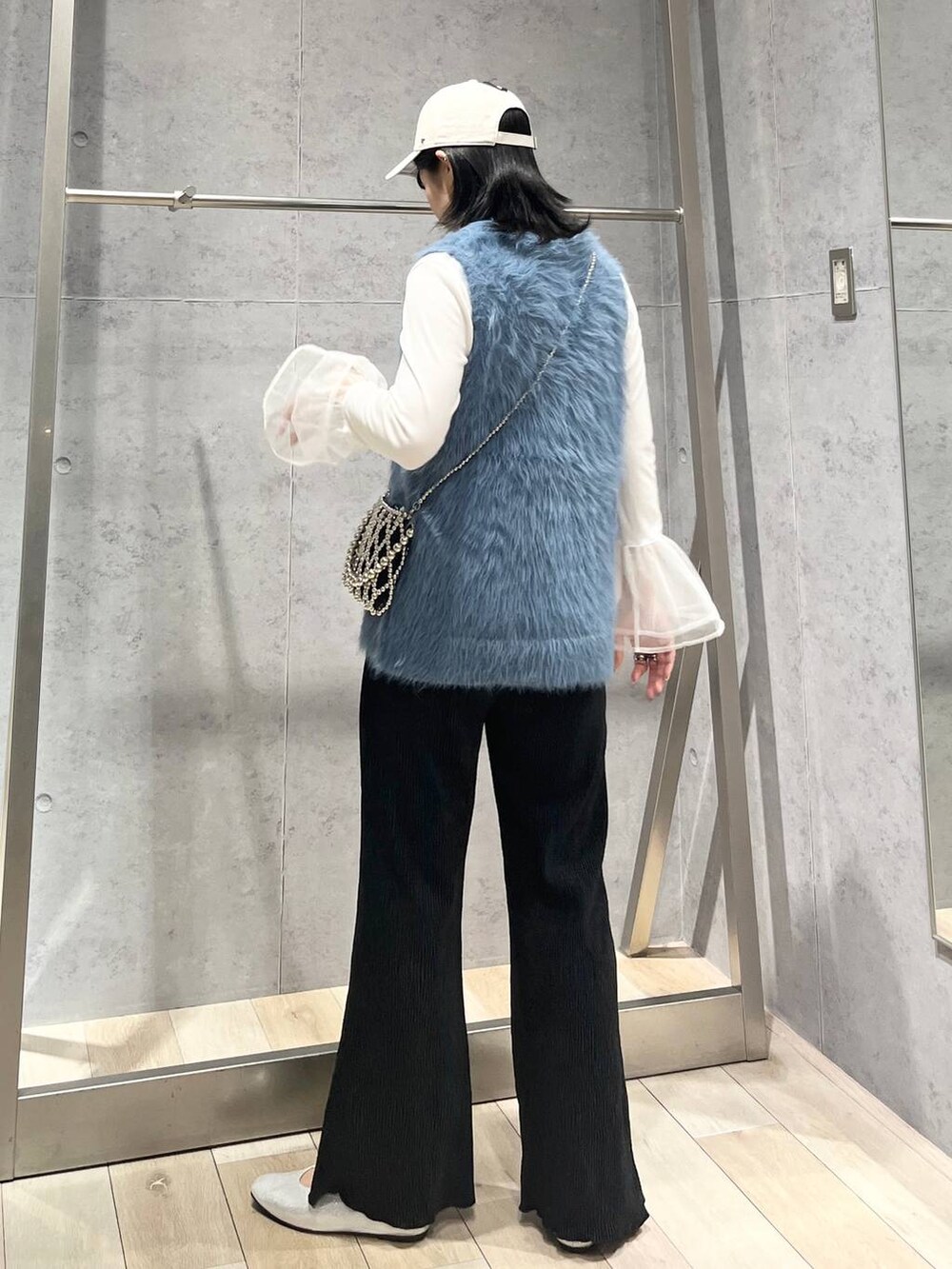 シルバー系のパンプス、ホワイト系のTシャツ/カットソー、ブルー系のベストを着用したレディースの秋コーディネートの3枚目の写真