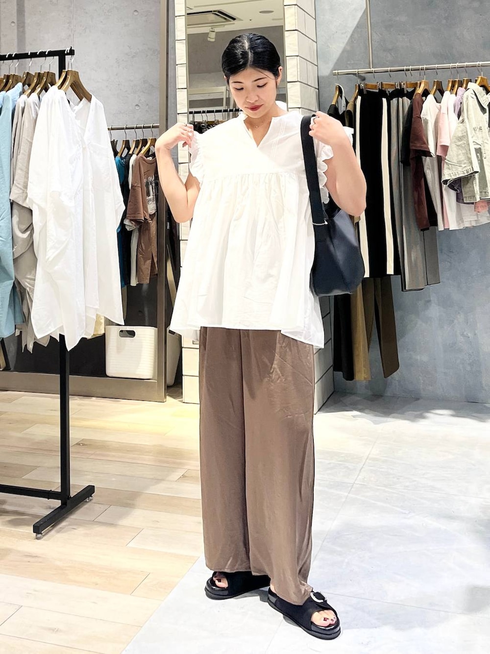 ブラック系のサンダル、ブラウン系のその他パンツ、ブラック系のショルダーバッグを着用したレディースの夏コーディネートの2枚目の写真