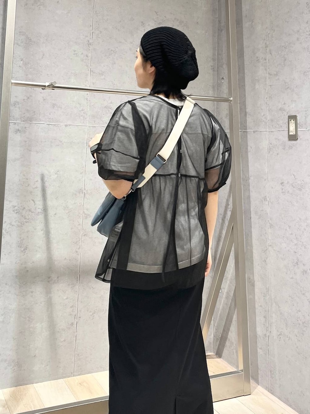 ブルー系のショルダーバッグ、ブラック系のスカート、ホワイト系のサンダルを着用したレディースの春コーディネートの7枚目の写真