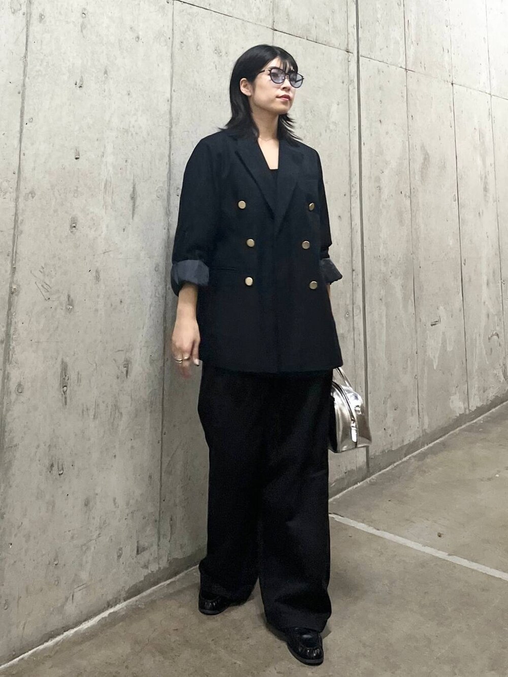 ブルー系のテーラードジャケット、シルバー系のボストンバッグ、グレー系のチノパンツを着用したレディースの秋コーディネートの3枚目の写真