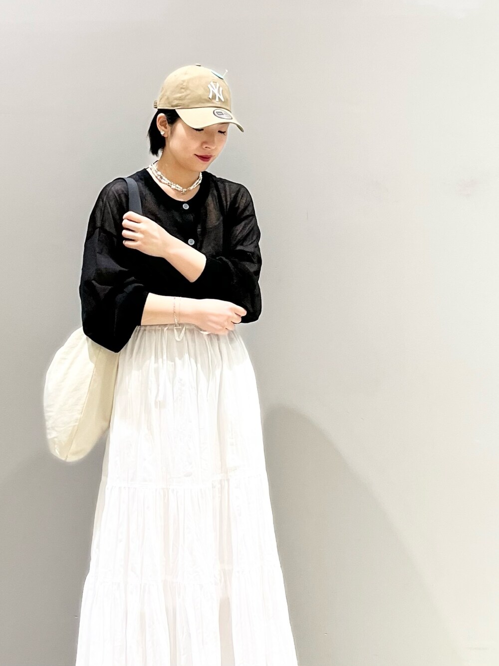 ブラック系のサンダル、ホワイト系のスカート、ホワイト系のショルダーバッグを着用したレディースの夏コーディネートの3枚目の写真