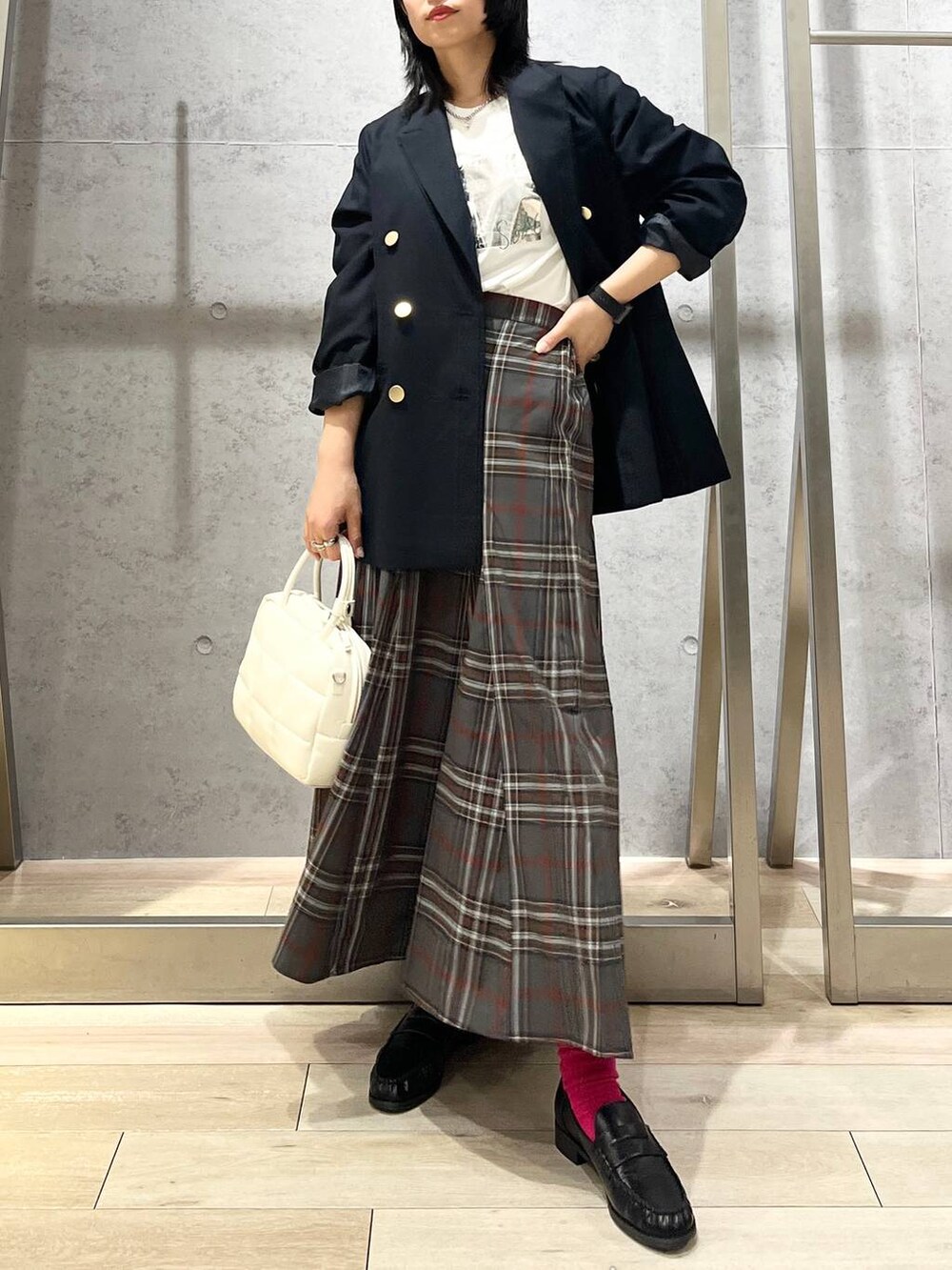 ブルー系のテーラードジャケット、ホワイト系のボストンバッグ、ブラック系のローファーを着用したレディースの秋コーディネートの6枚目の写真