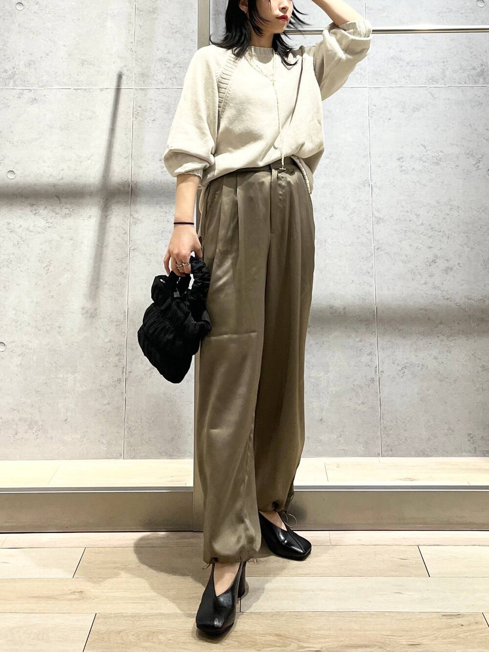 ブラック系のショルダーバッグ、ブラック系のパンプス、イエロー系のその他パンツを着用したレディースの冬コーディネートの6枚目の写真