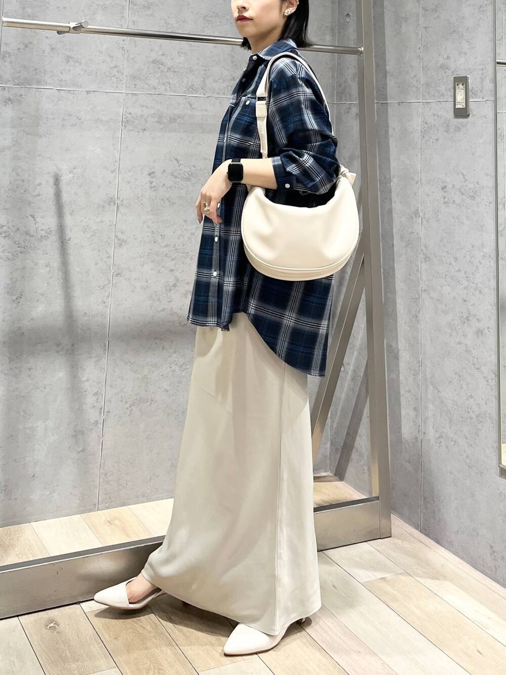 ホワイト系のショルダーバッグ、ホワイト系のスカート、ブルー系のシャツ/ブラウスを着用したレディースの冬コーディネートの3枚目の写真