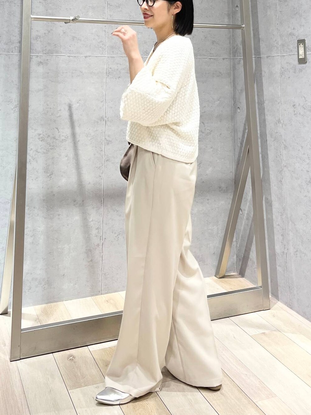 ブラウン系のハンドバッグ、グレー系のパンプス、ホワイト系のカーディガン/ボレロを着用したレディースの冬コーディネートの5枚目の写真