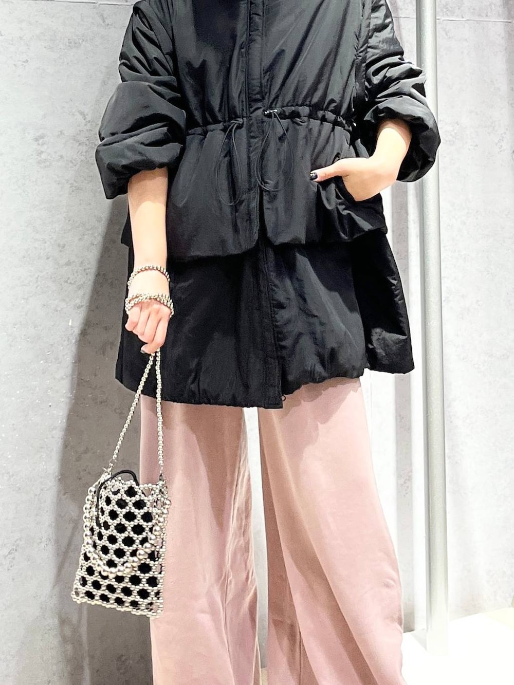 シルバー系のショルダーバッグ、ピンク系のスウェットパンツ、ブラック系のキャップを着用したレディースの秋コーディネートの6枚目の写真