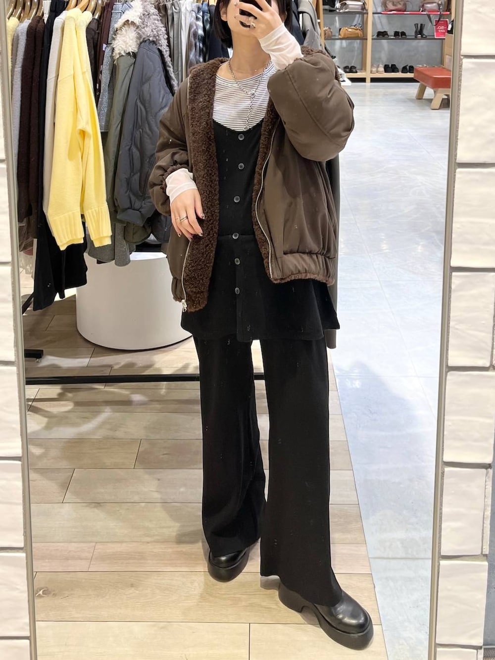 ホワイト系のTシャツ/カットソー、ブラウン系のブルゾン、ブラック系のその他シューズを着用したレディースの冬コーディネートの2枚目の写真