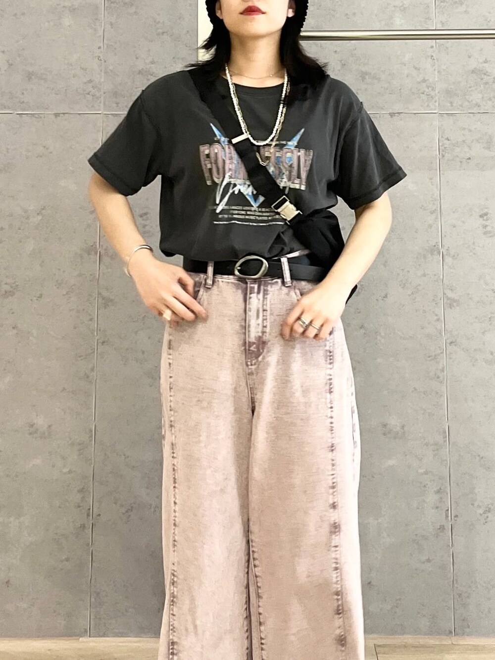 パープル系のデニムパンツ、ブラック系のショルダーバッグ、ブラック系のTシャツ/カットソーを着用したレディースの春コーディネートの8枚目の写真