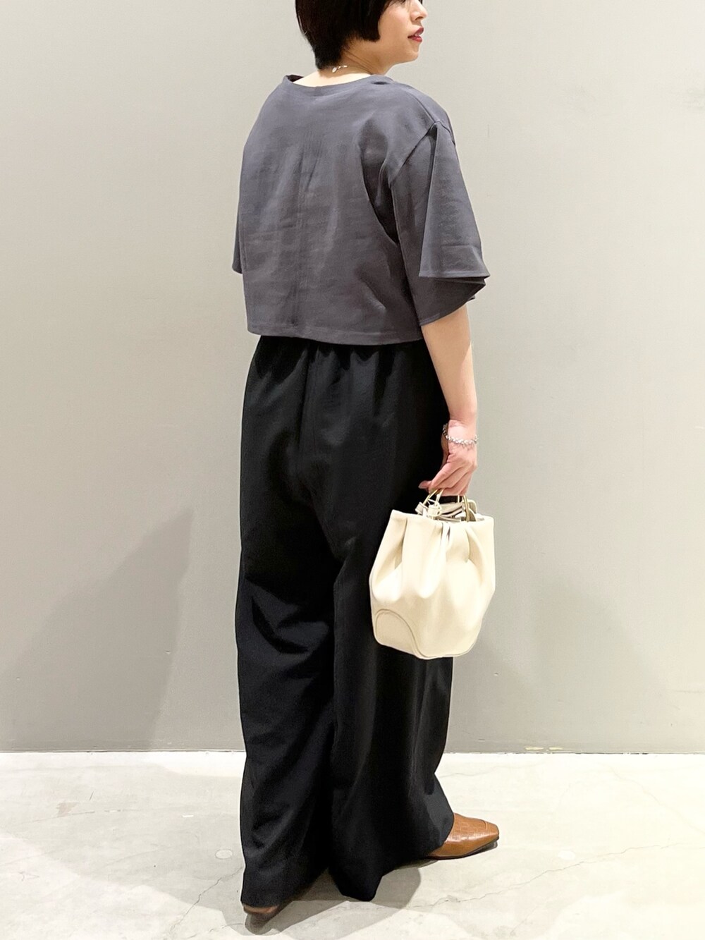 グレー系のTシャツ/カットソー、ブラック系のその他パンツ、ホワイト系のバッグを着用したレディースの春コーディネートの6枚目の写真