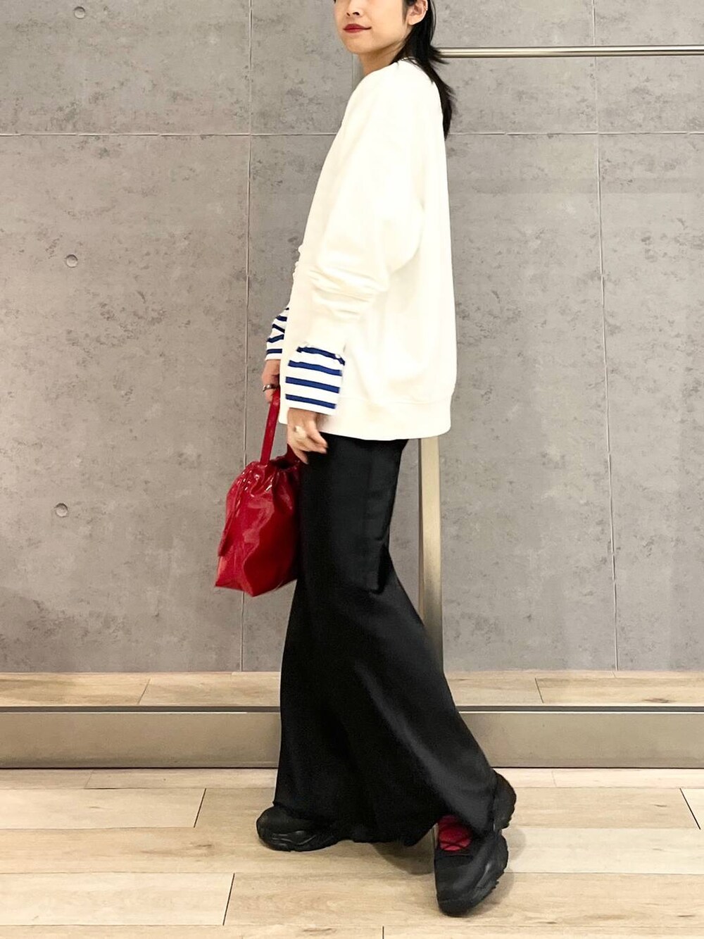 ブラック系のスカート、ブラック系のスニーカー、ホワイト系のスウェットを着用したレディースの冬コーディネートの4枚目の写真