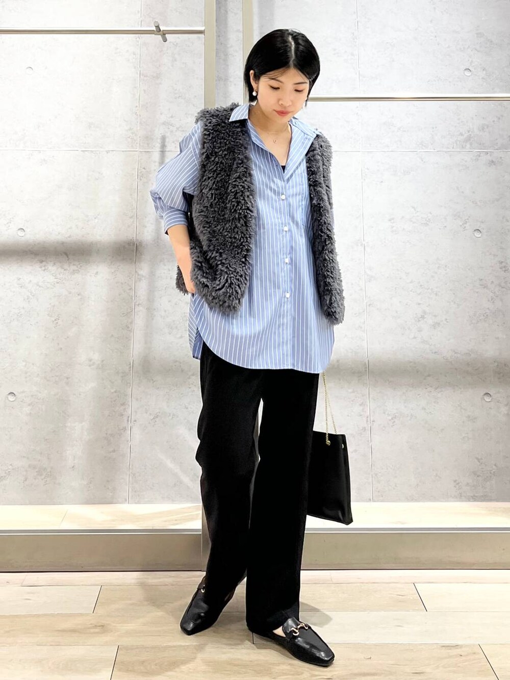 グレー系のベスト、ブラック系のその他パンツ、ブラック系のローファーを着用したレディースの秋コーディネートの4枚目の写真