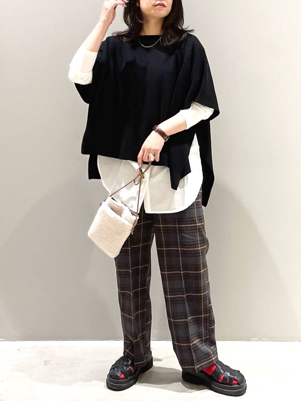 ホワイト系のTシャツ/カットソー、ブラウン系のパンツ、ブラック系のサンダルを着用したレディースの秋コーディネートの4枚目の写真