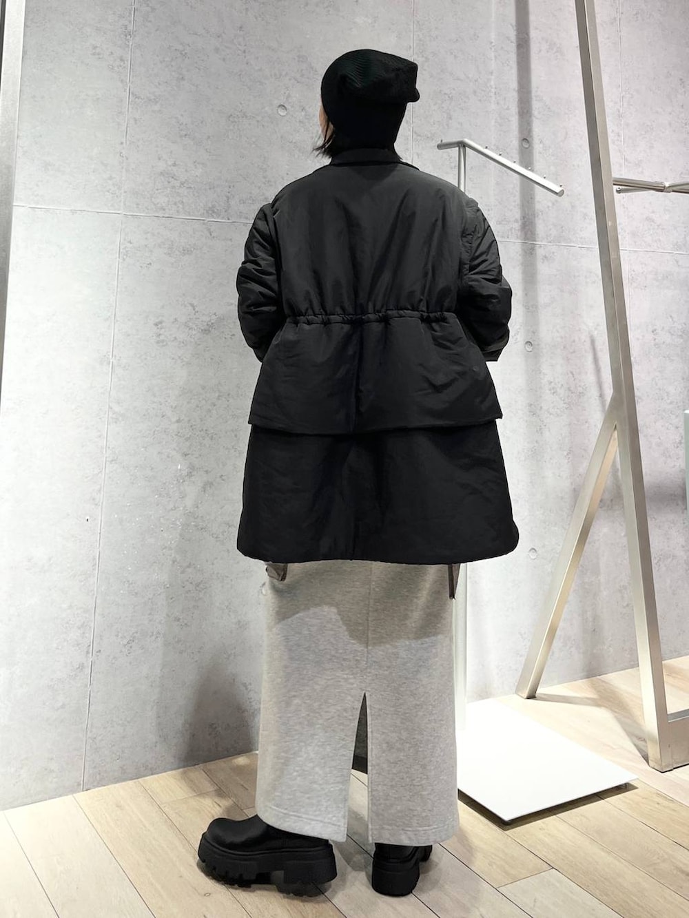 グレー系のスカート、ブラック系のボストンバッグ、ブラック系のブーツを着用したレディースの秋コーディネートの6枚目の写真