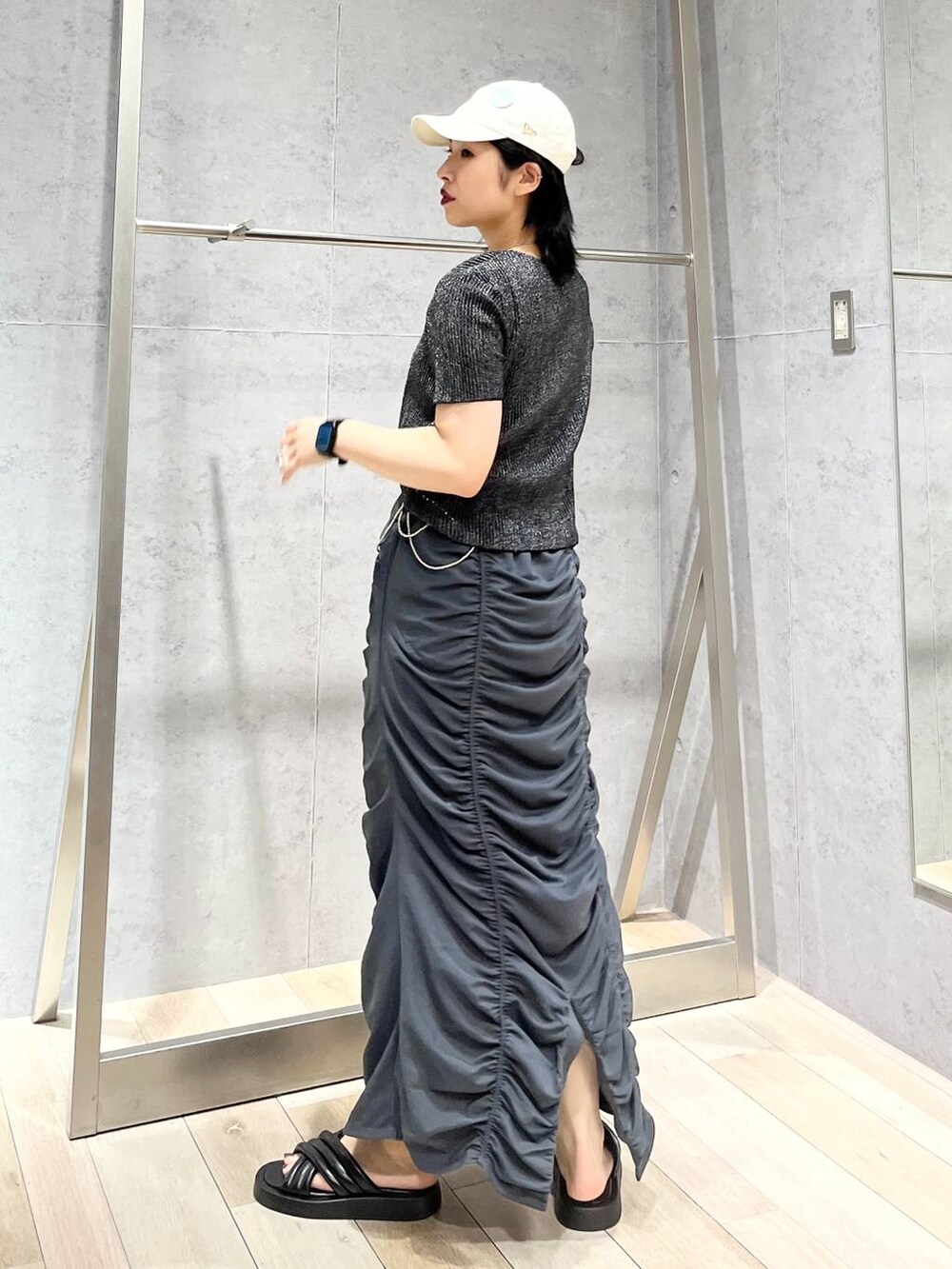 グレー系のスカート、ブラック系のサンダル、ブラック系のTシャツ/カットソーを着用したレディースの夏コーディネートの4枚目の写真