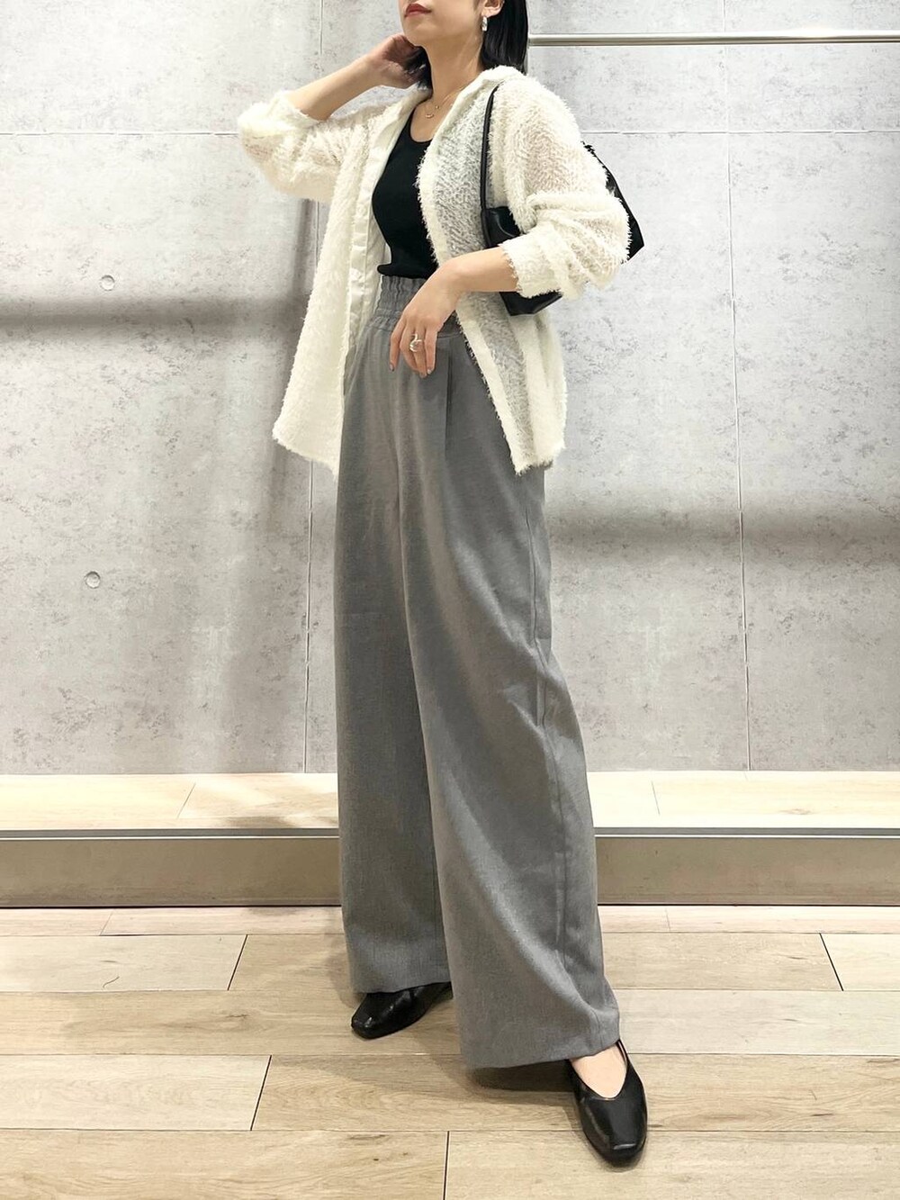 ブラック系のハンドバッグ、ホワイト系のシャツ/ブラウス、ブラック系のパンプスを着用したレディースの春コーディネートの3枚目の写真