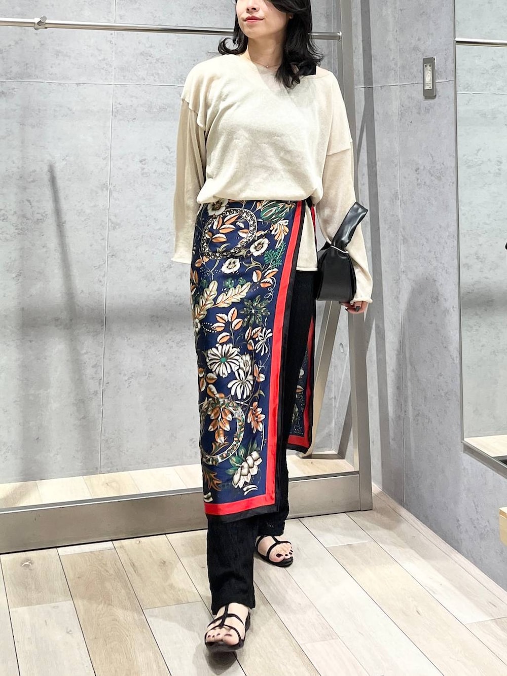 ブラック系のハンドバッグ、ベージュ系のニット/セーター、ブラック系のその他パンツを着用したレディースの春コーディネートの2枚目の写真