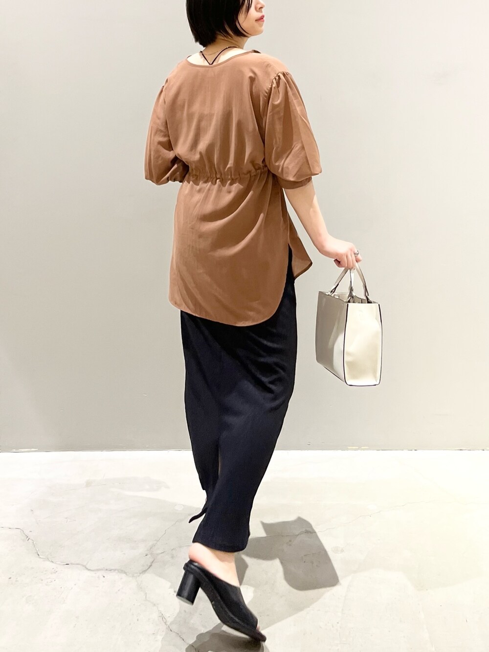 イエロー系のシャツ/ブラウス、ブラック系のスカート、ブラウン系のバッグを着用したレディースの秋コーディネートの3枚目の写真