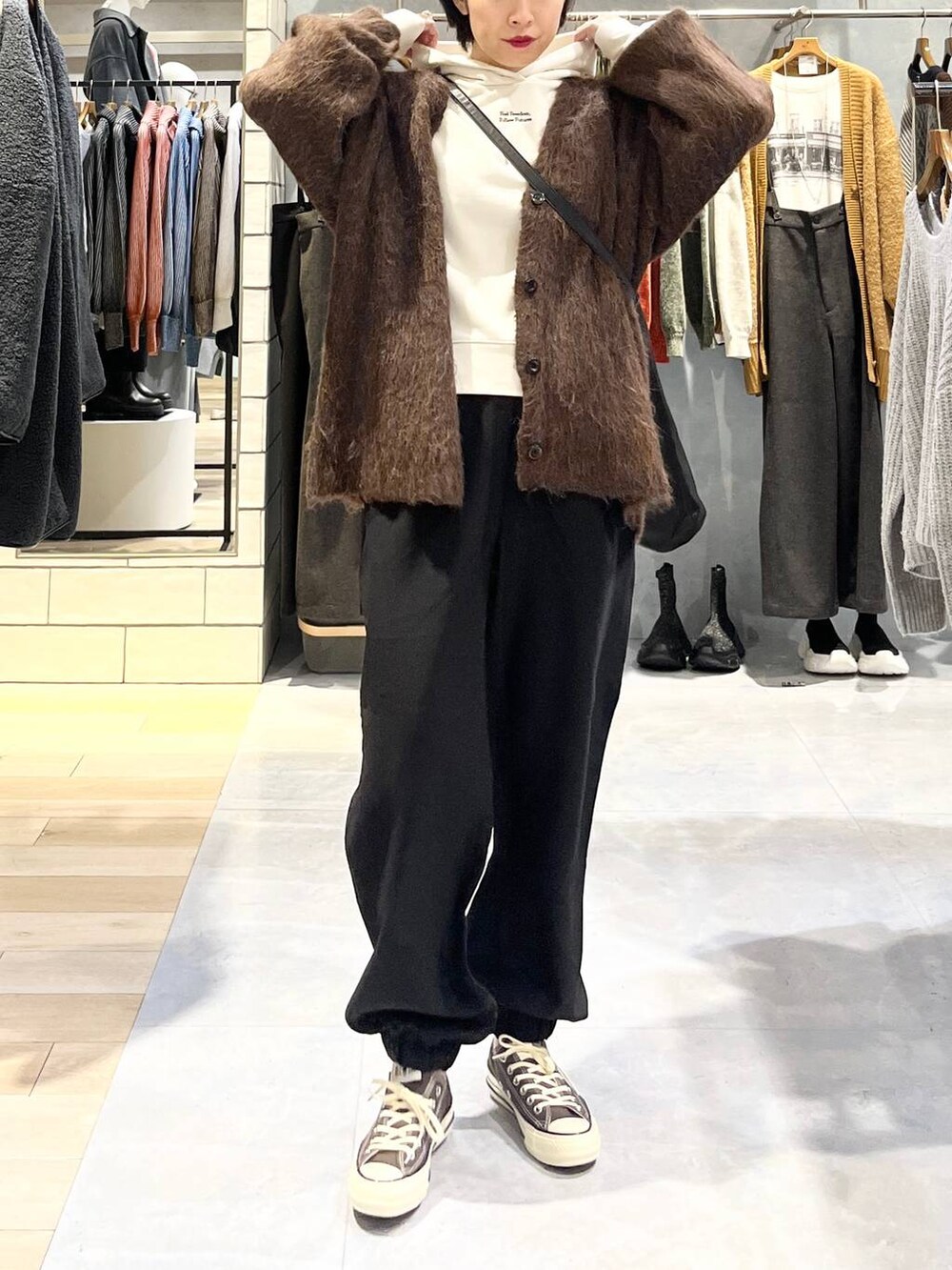 ブラウン系のスニーカー、ブラック系のその他パンツ、ブラウン系のカーディガン/ボレロを着用したレディースの秋コーディネートの7枚目の写真
