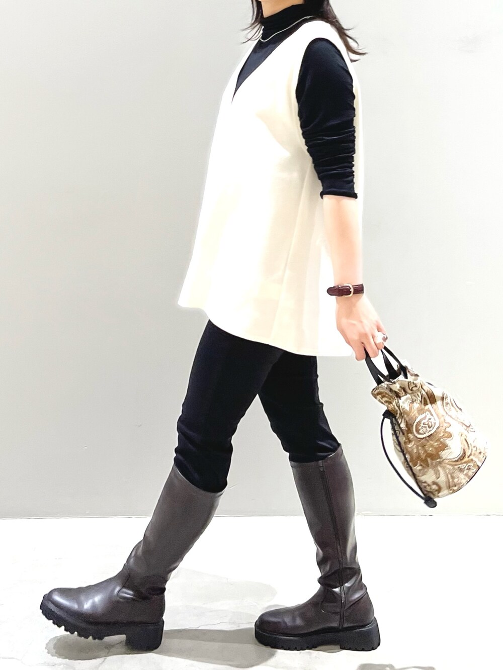 ブラウン系のショルダーバッグ、ブラウン系のブーツ、ブラック系のその他パンツを着用したレディースの秋コーディネートの4枚目の写真