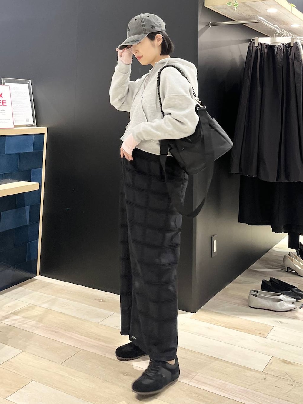 ピンク系のTシャツ/カットソー、ブラック系のショルダーバッグ、ブラック系のスニーカーを着用したレディースの春コーディネートの3枚目の写真