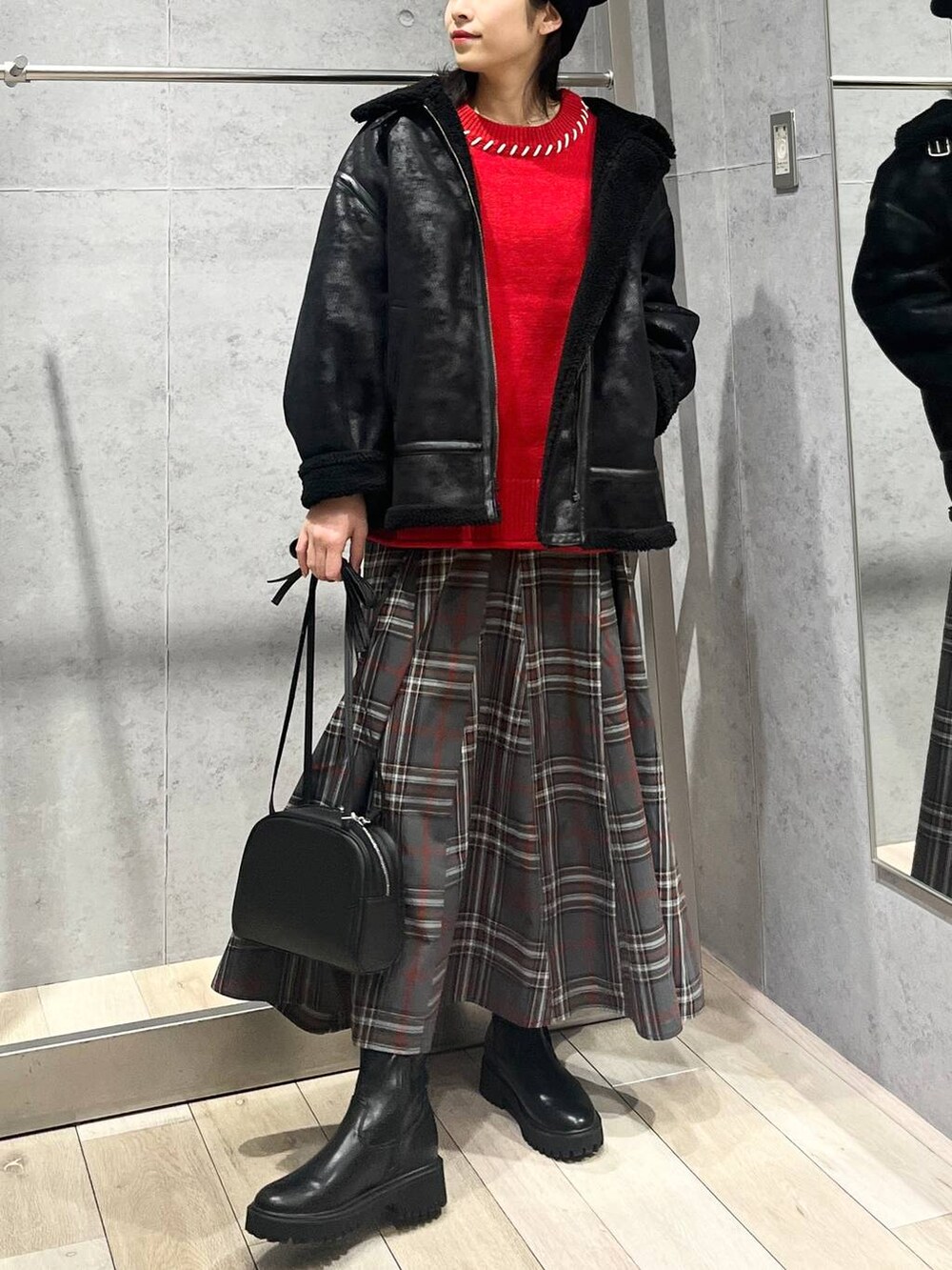 ブラック系のブーツ、ブラック系のその他アウター、グレー系のスカートを着用したレディースの冬コーディネートの8枚目の写真