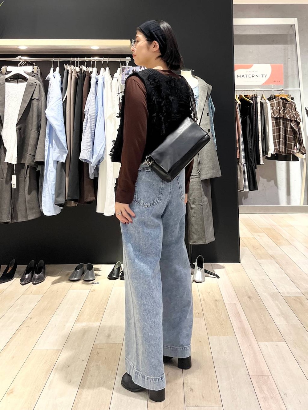 ブルー系のデニムパンツ、ブラック系のショルダーバッグ、ブラック系のその他シューズを着用したレディースの秋コーディネートの3枚目の写真