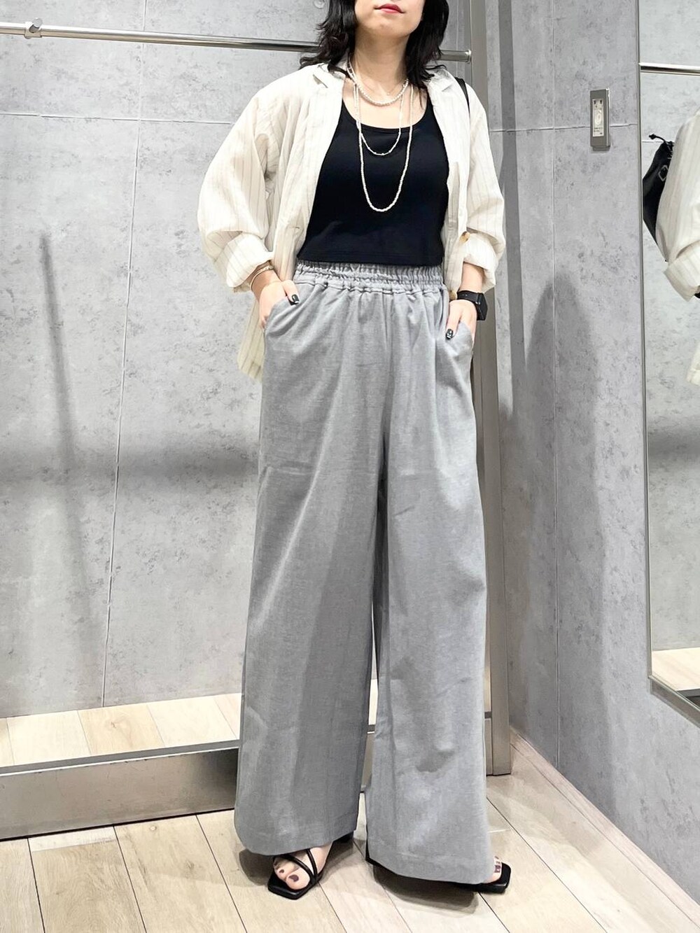 グレー系のその他パンツ、ブラック系のショルダーバッグ、ホワイト系のシャツ/ブラウスを着用したレディースの春コーディネートの4枚目の写真