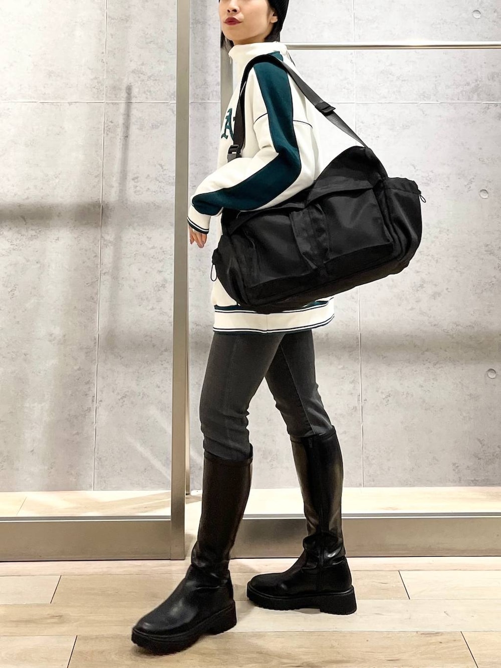 ホワイト系のTシャツ/カットソー、ブラック系のブーツ、グレー系のデニムパンツを着用したレディースの冬コーディネートの2枚目の写真