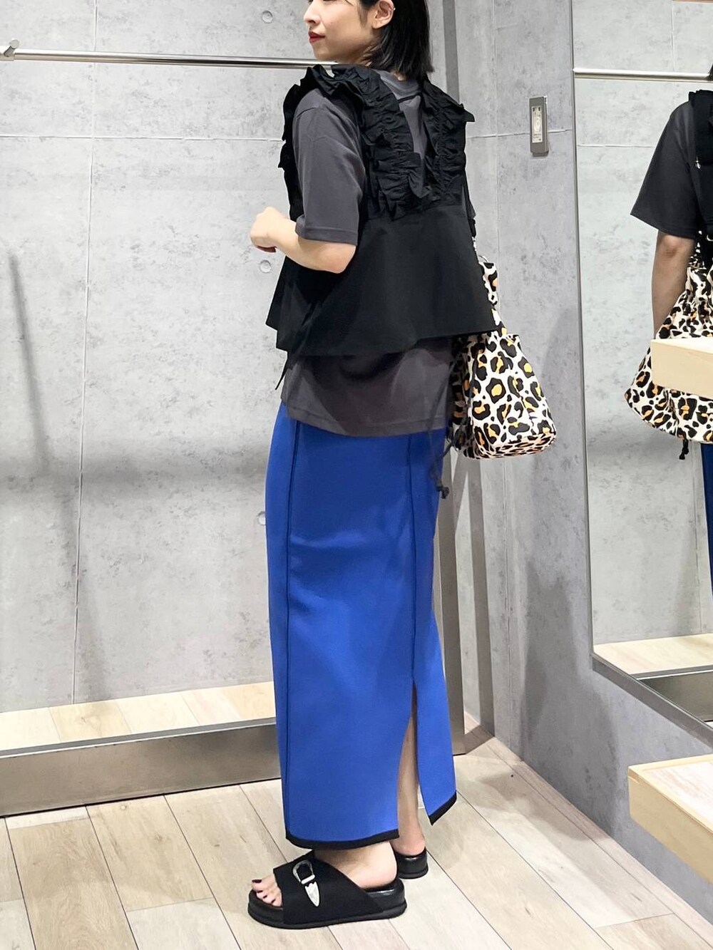 ブラック系のサンダル、ブラック系のベストを着用したレディースの夏コーディネートの2枚目の写真