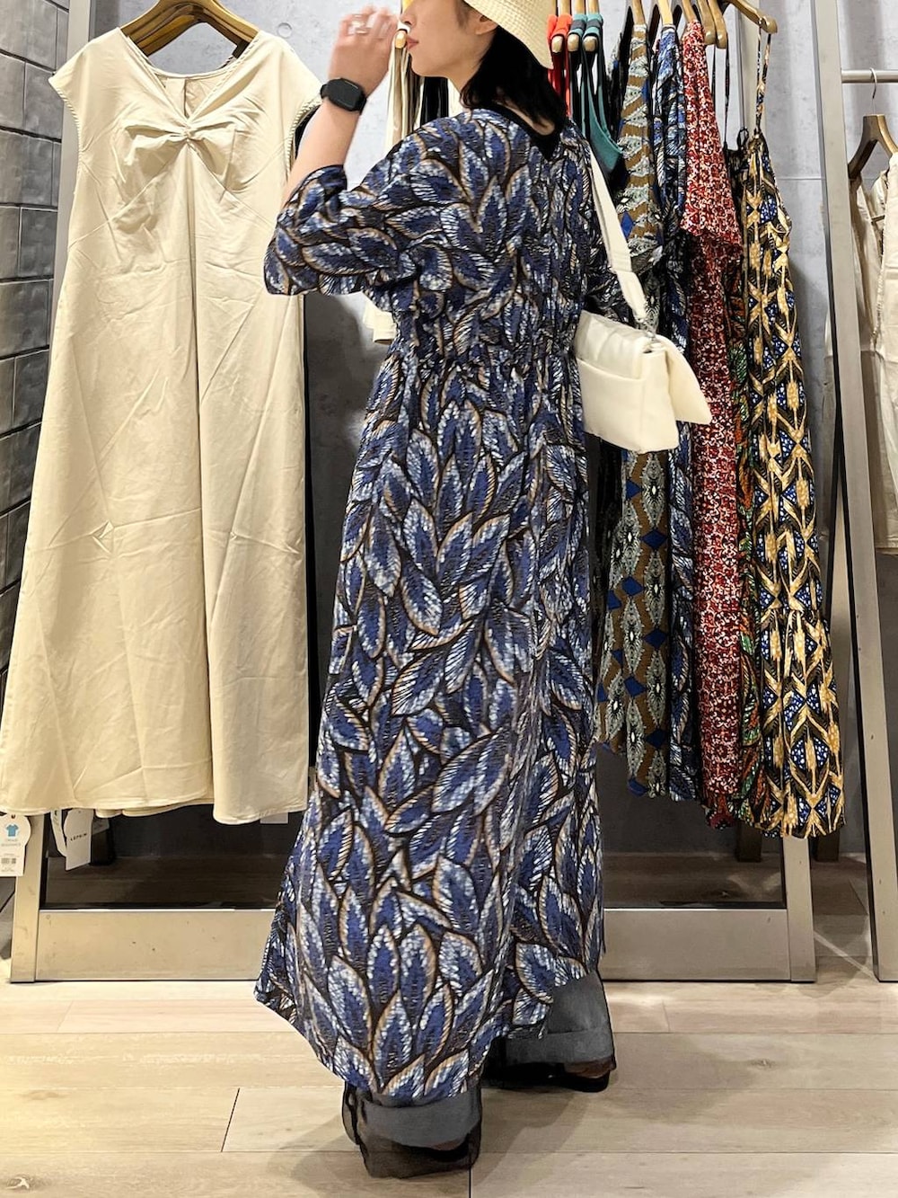 ホワイト系のショルダーバッグ、ブラック系のサンダル、ブルー系のデニムパンツを着用したレディースの夏コーディネートの7枚目の写真