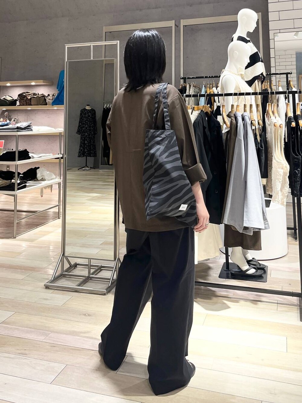 ブラック系のサンダル、グレー系のトートバッグ、ホワイト系のキャミソールを着用したレディースの夏コーディネートの7枚目の写真