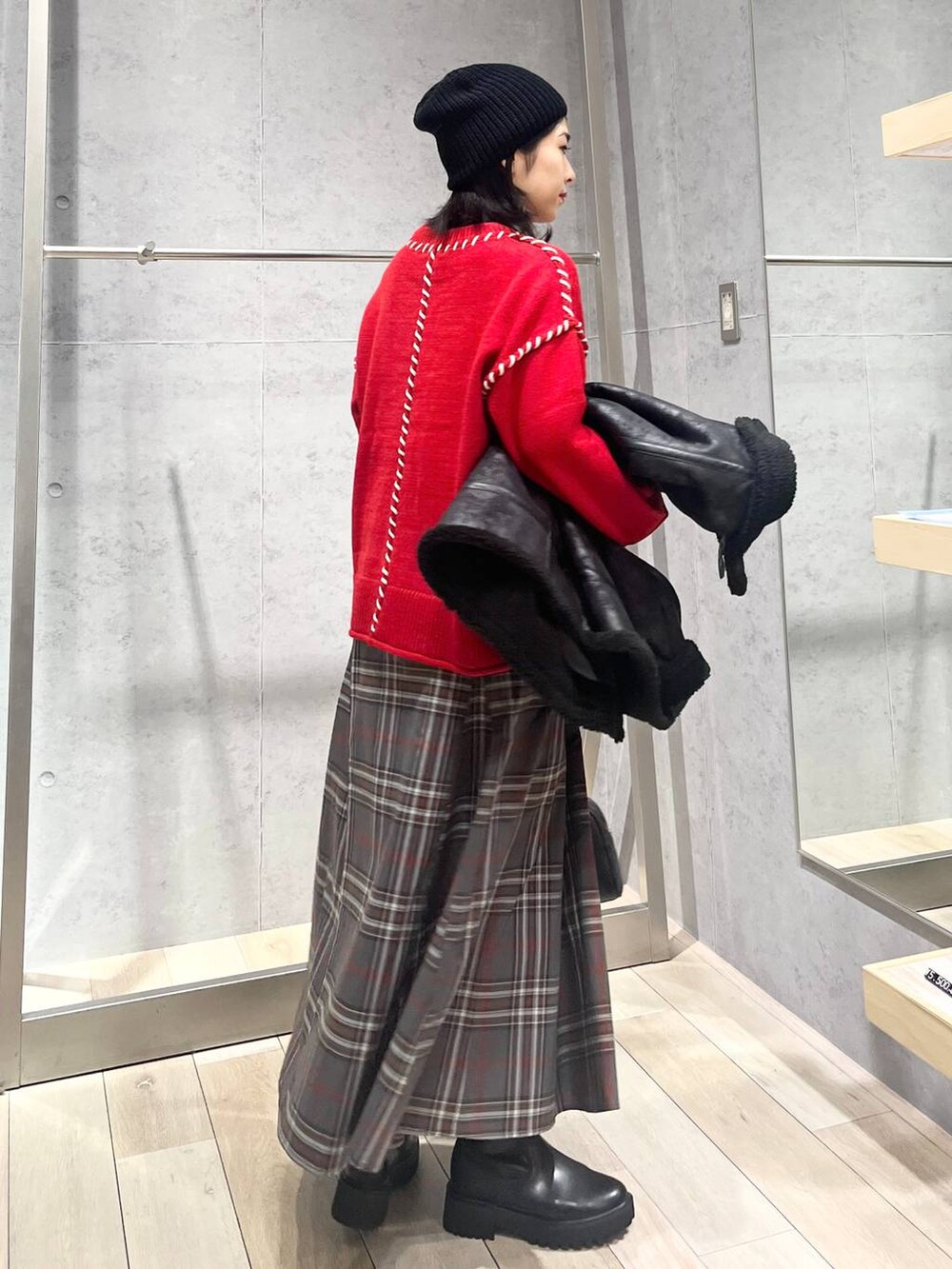 ブラック系のブーツ、ブラック系のその他アウター、グレー系のスカートを着用したレディースの冬コーディネートの4枚目の写真