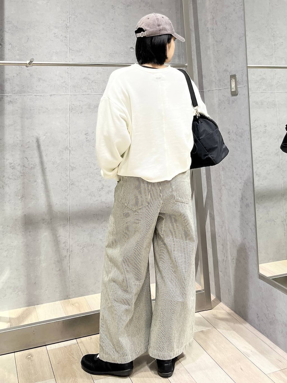 ブラック系のTシャツ/カットソー、ブラック系のショルダーバッグ、ブラック系のパンプスを着用したレディースの冬コーディネートの3枚目の写真