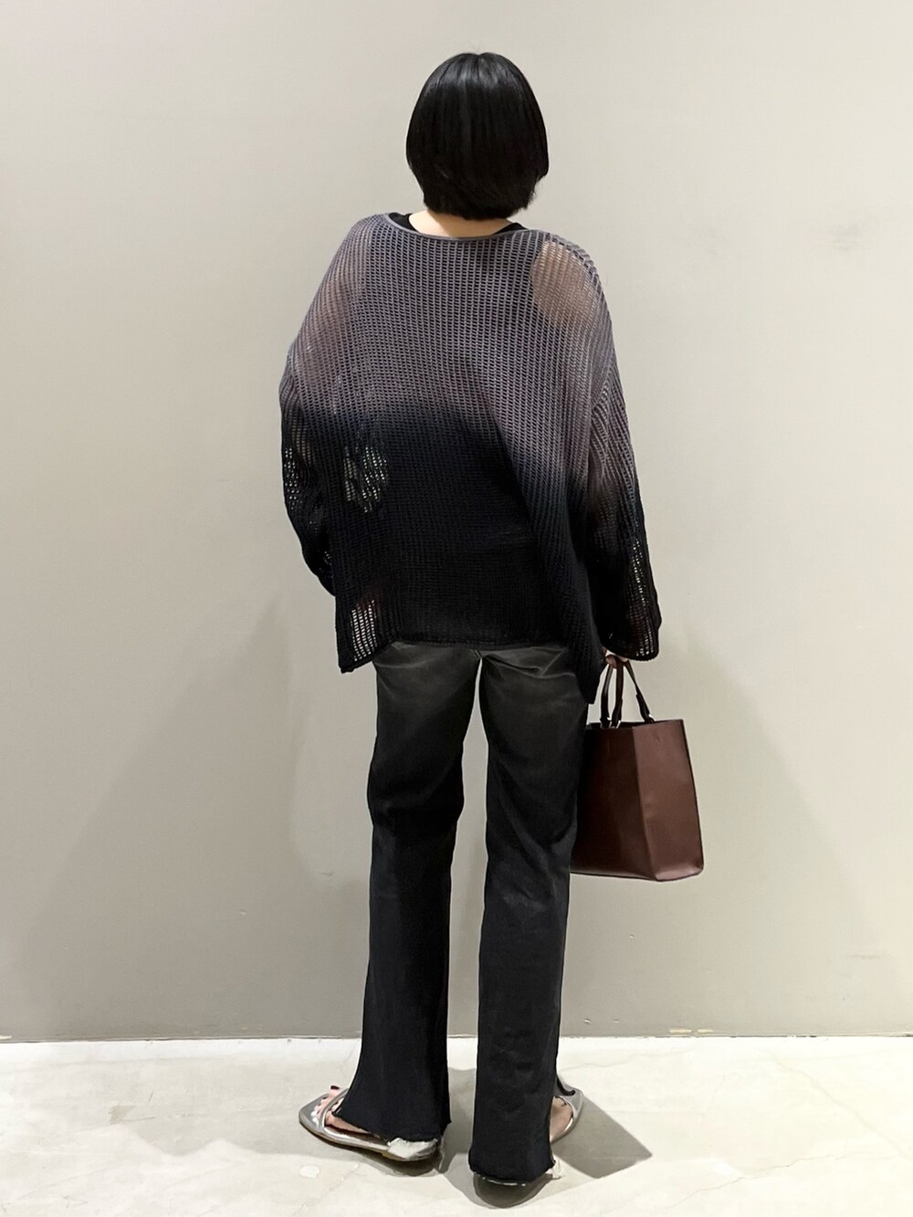 ブラック系のデニムパンツ、ブラウン系のバッグ、シルバー系のサンダルを着用したレディースの夏コーディネートの5枚目の写真