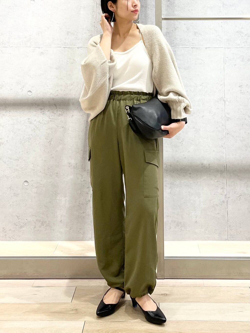 ホワイト系のキャミソール、ベージュ系のカーディガン/ボレロ、グリーン系のカーゴパンツを着用したレディースの秋コーディネートの7枚目の写真