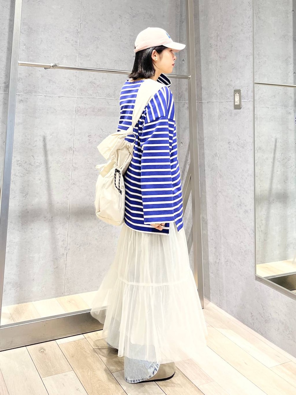 ホワイト系のスカート、パープル系のTシャツ/カットソー、ブルー系のデニムパンツを着用したレディースの冬コーディネートの3枚目の写真