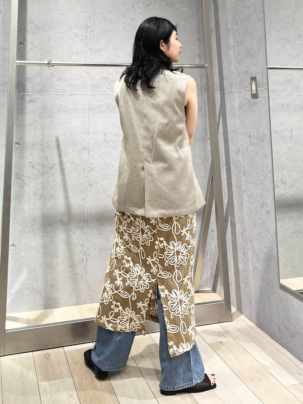 ブルー系のデニムパンツ、ブラック系のハンドバッグ、ブラック系のサンダルを着用したレディースの春コーディネートの5枚目の写真