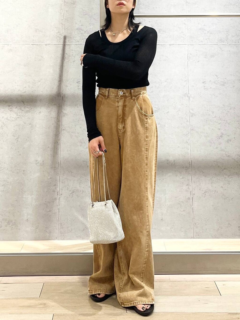 シルバー系のショルダーバッグ、ブラック系のサンダル、ブラック系のTシャツ/カットソーを着用したレディースの夏コーディネートの2枚目の写真