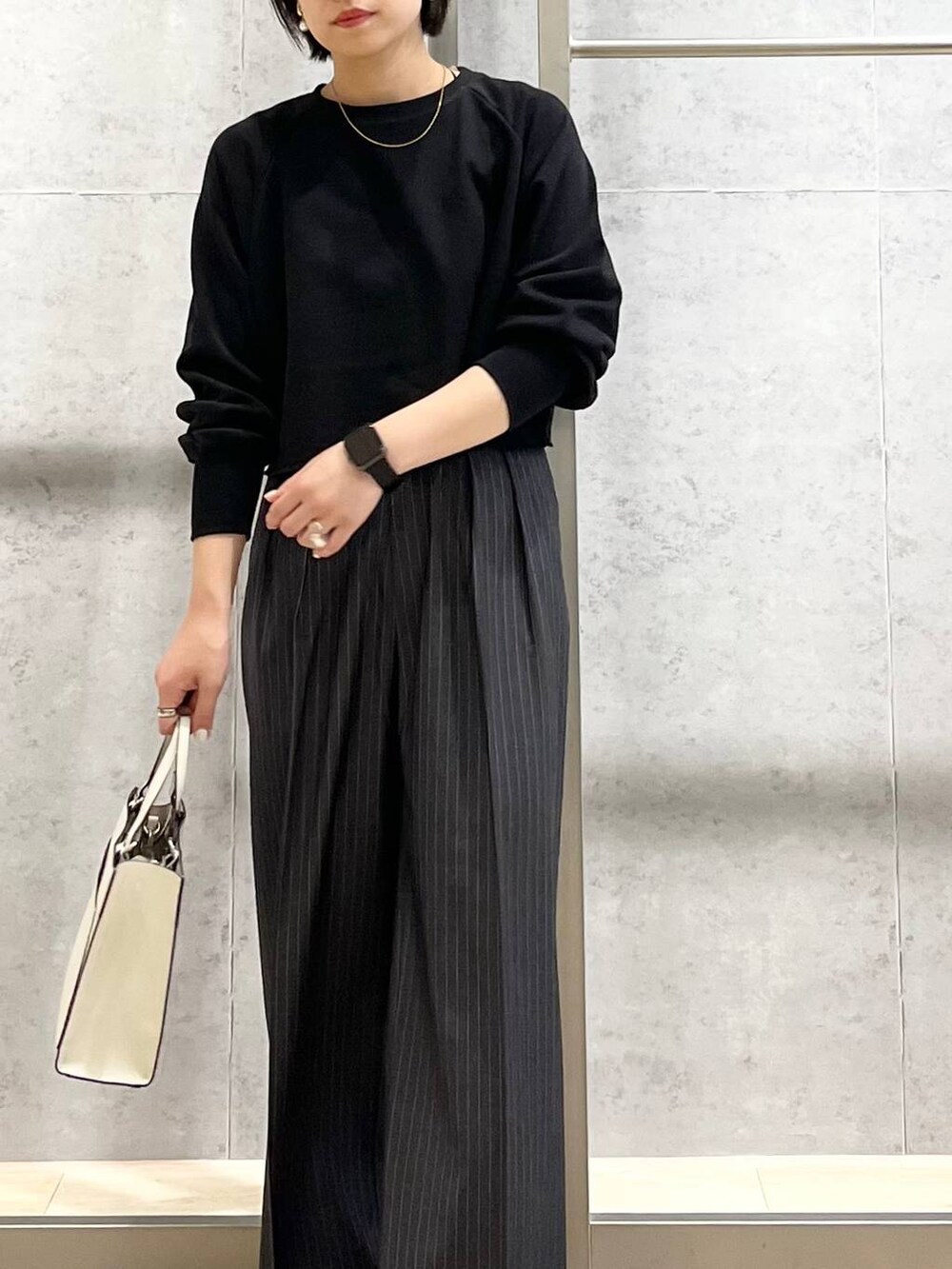 ブラック系のTシャツ/カットソー、ホワイト系のショルダーバッグ、グレー系のその他パンツを着用したレディースの秋コーディネートの8枚目の写真