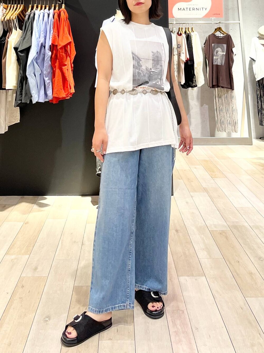 ブラック系のサンダル、ブルー系のデニムパンツ、ブラック系のショルダーバッグを着用したレディースの夏コーディネートの4枚目の写真