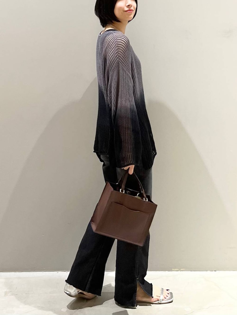ブラック系のニット/セーター、シルバー系のサンダル、ブラック系のデニムパンツを着用したレディースの夏コーディネートの9枚目の写真